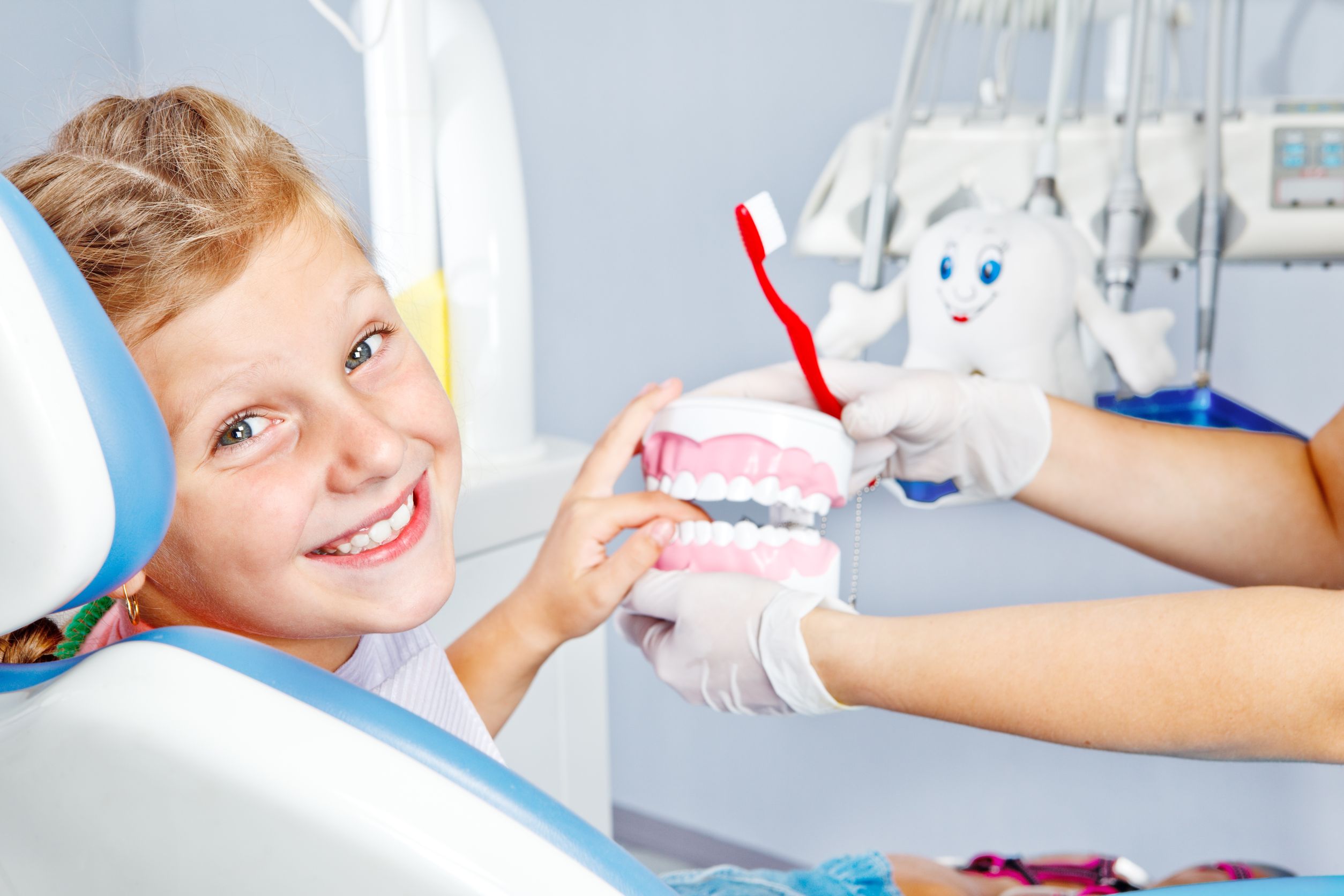 boy holding teeth and a red toothbrush