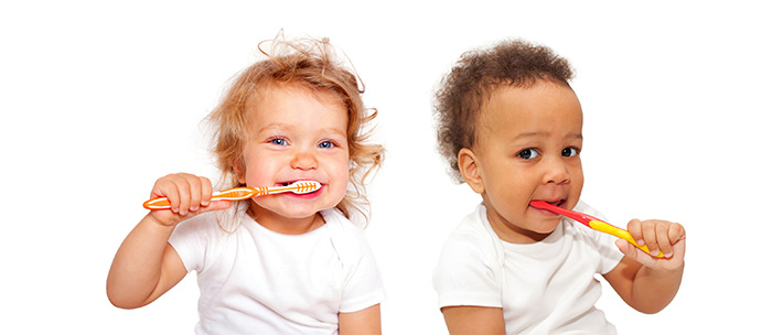 Young children brushing their teeth, featured on a page about cavity fillings in Wilson, NC.