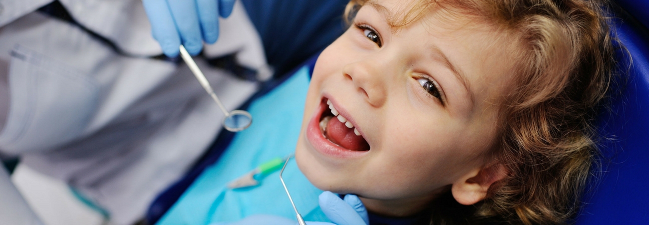 pediatric patient at a kid's dentist having his teeth examined